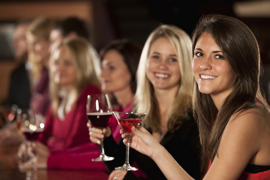 Smiling Young Female Friends Enjoying Drinks