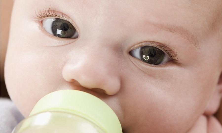 Close up of baby drinking from bottle
