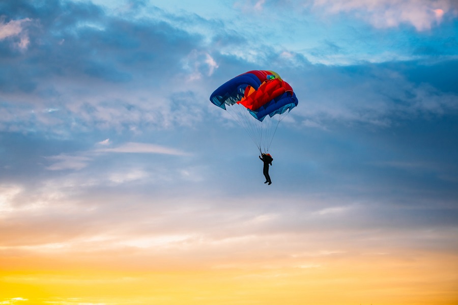 Skydiver On Colorful Parachute In Sunny Sunset Sunrise Sky. Active Hobbies